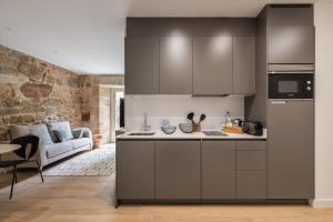 a kitchen with gray cabinets and a living room at Bow Monumental by Como en Casa in Vigo