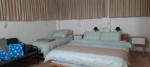 um quarto com duas camas e uma cadeira. em har nof apartment em Jerusalém