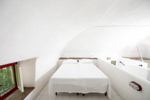 a white room with a bed and a window at MAMMAAMIIIAA!!!!! Exclusive TERRACE in Chiaiolella in Procida