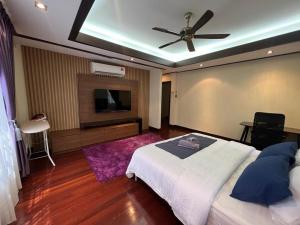 sypialnia z łóżkiem i wentylatorem sufitowym w obiekcie Mawar Singgah w mieście Putrajaya