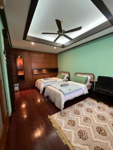 sypialnia z 2 łóżkami i wentylatorem sufitowym w obiekcie Mawar Singgah w mieście Putrajaya