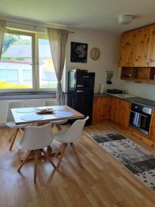 La cuisine est équipée d'une table, de chaises et d'un réfrigérateur. dans l'établissement Stadtwohnung in Rohrbach, à Rohrbach in Oberösterreich