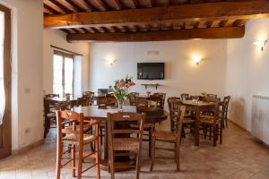 a dining room with tables and chairs and a tv at Pugnano Alto - appartamento Tabacco in Lisciano Niccone