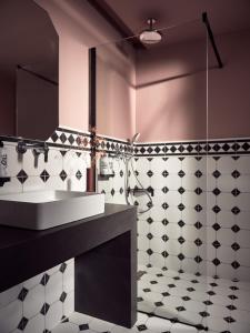 un bagno con lavandino e piastrelle bianche e nere di Anemelia Retreat a Laganas