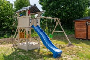 a wooden playground with a slide and a swing at Apartamenty Pod Cisem Lux in Kudowa-Zdrój
