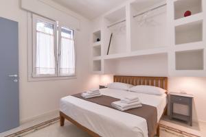 a white bedroom with a bed with towels on it at Casa dei Nonni in Avetrana