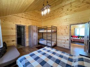 a bedroom with a bed in a wooden cabin at Земляничная поляна Боровое in Shchuchinskiy