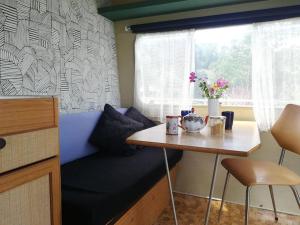 a small room with a table and a window at Cute little caravan for 2 in old orchard in Hem
