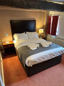 a bedroom with a large bed with two pillows on it at The Queens Head Inn in Milton Ernest