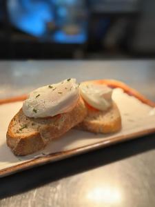 deux morceaux de pain avec du beurre et des oignons sur une assiette dans l'établissement The Queens Head Inn, à Milton Ernest