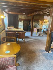 a dining room with tables and chairs and a fireplace at The Queens Head Inn in Milton Ernest