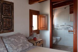 a bedroom with a bed and a bathroom with a toilet at Sa Guardia de Ferricci in Solanas