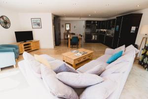 a living room with a white couch and a table at Trewhiddle Retreat V10 by Together Travel - Luxury 4-Bedroom Villa in St Austell