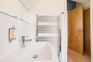 a white bathroom with a sink and a mirror at Trewhiddle Retreat V10 by Together Travel - Luxury 4-Bedroom Villa in St Austell +48 photos