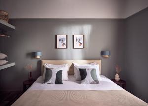una camera con un letto con tre immagini appese al muro di Anemelia Retreat a Laganas