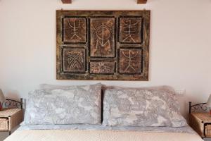 a picture hanging above a bed in a room at Sa Guardia de Ferricci in Solanas