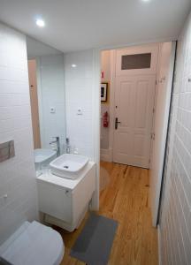 een badkamer met een toilet, een wastafel en een spiegel bij OPorto Histórico - Galerias in Porto