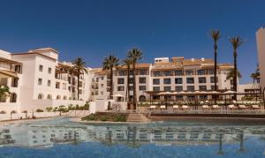 un hotel con piscina di fronte a un edificio di La Zambra Resort GL, part of The Unbound Collection by Hyatt a Mijas