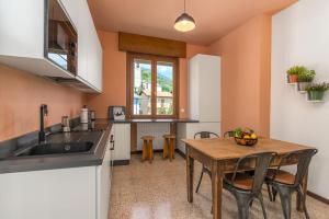 cocina con mesa de madera y cocina con fregadero en Vivi Il Lago - Lake View, en Cernobbio