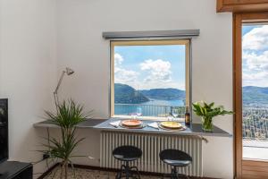 una mesa con dos platos de comida y una ventana en Vivi Il Lago - Lake View, en Cernobbio