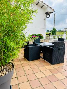 eine Terrasse mit einem Tisch, Stühlen und Pflanzen in der Unterkunft Apartamentos Nel I in Santillana del Mar