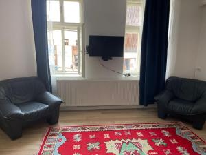 a living room with two chairs and a red rug at Turnul Portii in Sibiu