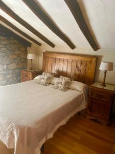 a bedroom with a large bed with two night stands and two lamps at Apartamentos Nel I in Santillana del Mar