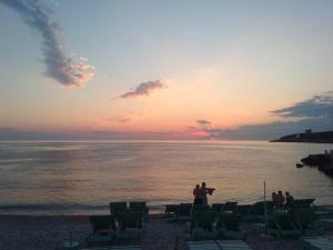 a man taking a picture of the sunset at the beach at Kod Senada in Utjeha