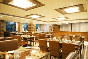 un restaurante con mesas y sillas en una habitación en Boulevard 9 Luxury Resort & Spa, en Nadiād