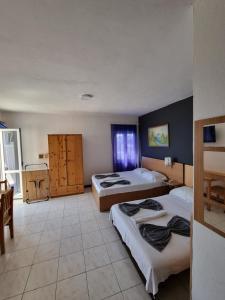 Habitación de hotel con 2 camas y mesa en Apartments Adriatik, en Ulcinj