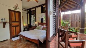 1 dormitorio con 1 cama y balcón en Greenheart Boutique Hotel, en Paramaribo