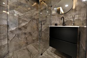 uma casa de banho com um lavatório e um espelho em חלום מול הים - סוויטת נופש יוקרתית עם ג'קוזי ונוף לים em Haifa