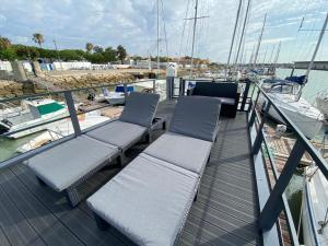 a deck of a boat with two chairs on it at Houseboat Cádiz El Puerto - Casa Flotante in El Puerto de Santa María