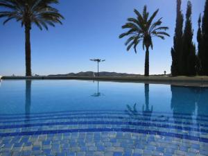una piscina con palmeras en el fondo en Las Estrellas, en Mijas