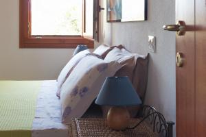 a bedroom with a bed with a blue lamp on a table at Sa Guardia de Ferricci in Solanas