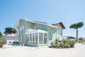 una casa verde con finiture bianche su una spiaggia di Fiori di Cardo - Agrimare a Cervia