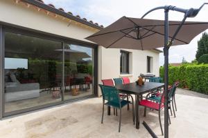 - une table et des chaises avec un parasol sur la terrasse dans l'établissement La Villa d'Angèle - Villa climatisée avec piscine, à Saint-Victor-la-Coste