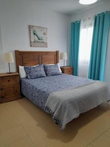 a bedroom with a bed and blue curtains at Miguelangelo in Los Llanos de Aridane