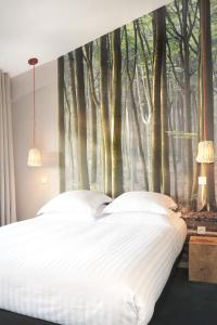 a bedroom with a large tree mural on the wall at L’Échappée Belle in LʼIsle-Jourdain