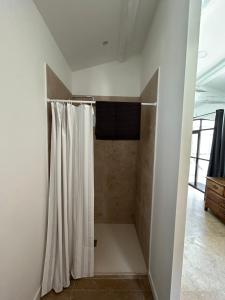 een badkamer met een douche en een douchegordijn bij chambre d'hôte sur le golf de pont royal in Mallemort