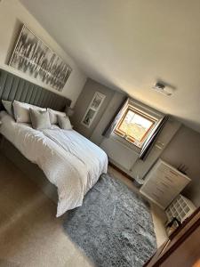 a bedroom with a bed and a window and a rug at Holmleigh Annexe in Tamworth