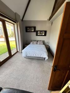 1 dormitorio con cama y ventana grande en Holmleigh Annexe en Tamworth