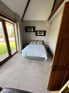 a bedroom with a bed and a large window at Holmleigh Annexe in Tamworth