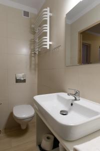 W łazience znajduje się umywalka, toaleta i lustro. w obiekcie Wydma Park w Rowach