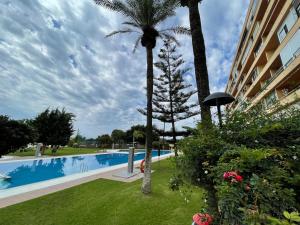 - une piscine avec un palmier à côté d'un bâtiment dans l'établissement Estudio con vistas, à Torremolinos
