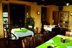 een restaurant met tafels en stoelen met groene tafelkleden bij Doppelzimmer 11 Gästehaus Mühlenstein in Bad Sülze