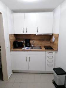 a kitchen with white cabinets and a sink at Doppelzimmer 11 Gästehaus Mühlenstein in Bad Sülze