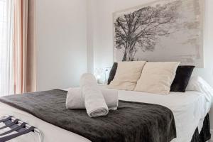 1 dormitorio con 1 cama con 2 toallas en Apartamentos Recaredo 7 , 2ª planta en Sevilla