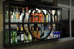 a shelf filled with lots of bottles of alcohol at Galaxy Motel Kampala in Kampala