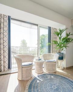 a living room with chairs and a large window at Villa Pastelowa in Jastarnia